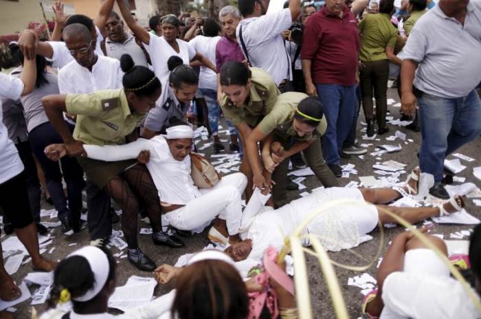 Police officers pick up members of the 'Ladies in White' dissident group after breaking up the group's regular march, detaining about 50 people, hours before U.S. President Barack Obama arrives for a historic visit, in Havana, Cuba, March 20, 2016.