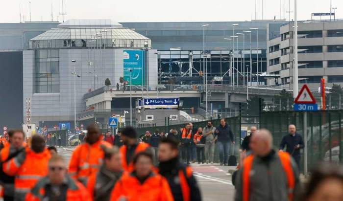 People leave the scene of explosions at Zaventem airport near Brussels, Belgium, March 22, 2016.