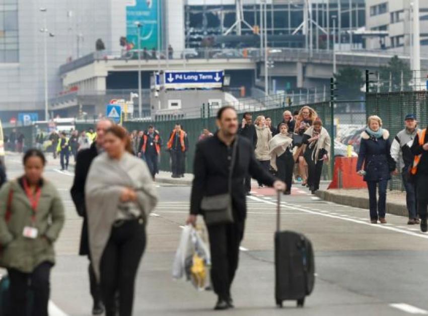 People leave the scene of explosions at Zaventem airport near Brussels, Belgium, March 22, 2016.