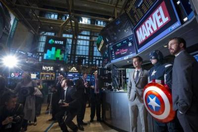 Actors Chris Evans (R) and Sebastian Stan (3rd R) pose for photographs with a man dressed as Captain America on the floor of the New York Stock Exchange April 1, 2014.