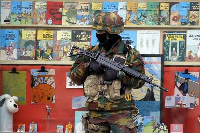 A Belgian soldier stands guard in front of a shop selling Tintin comic books in central Brussels, Belgium, March 24, 2016.