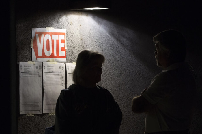 Early morning voters talk as they stand in line before sunrise to vote in Arizona's U.S. presidential primary election at a polling station in Cave Creek, Arizona, March 22, 2016.