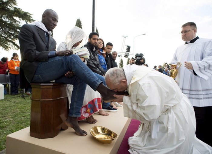 Pope Francis kisses the foot of a refugee during the foot washing ritual at the Castelnuovo di Porto refugees center near Rome, Italy, March 24, 2016.
