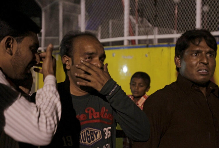 Men mourn the death of their relatives after a blast outside a public park in Lahore, Pakistan, March 27, 2016.