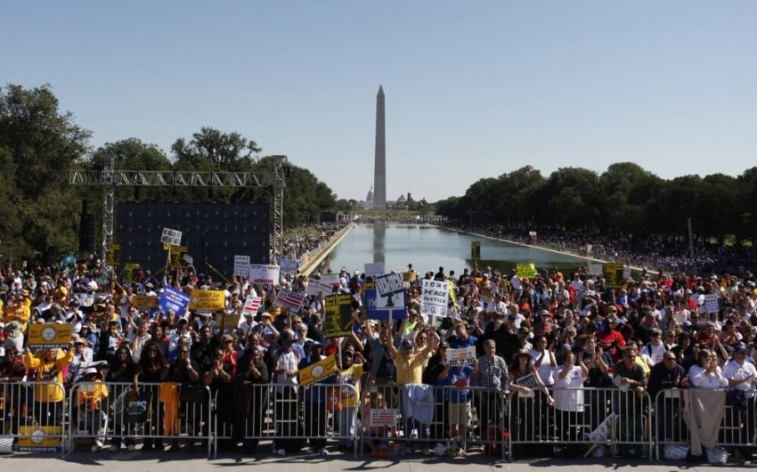 People shout slogans in front of the Reflecting Pool near the Washington Monument at the "One Nation Working Together" rally in Washington, D.C., October 2, 2010.