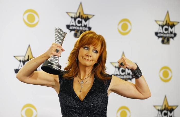 Singer Reba McEntire poses backstage with her Milestone Award at the 50th Annual Academy of Country Music Awards in Arlington, Texas, April 19, 2015.