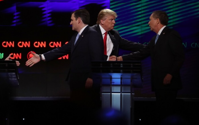 Republican U.S. presidential candidate Ted Cruz (C) reaches out to shake hands with rival Marco Rubio (not shown, at L) as Donald Trump (2nd R) shakes hands with John Kasich (R) at the end of the Republican U.S. presidential candidates debate sponsored by CNN at the University of Miami in Miami, Florida March 10, 2016.