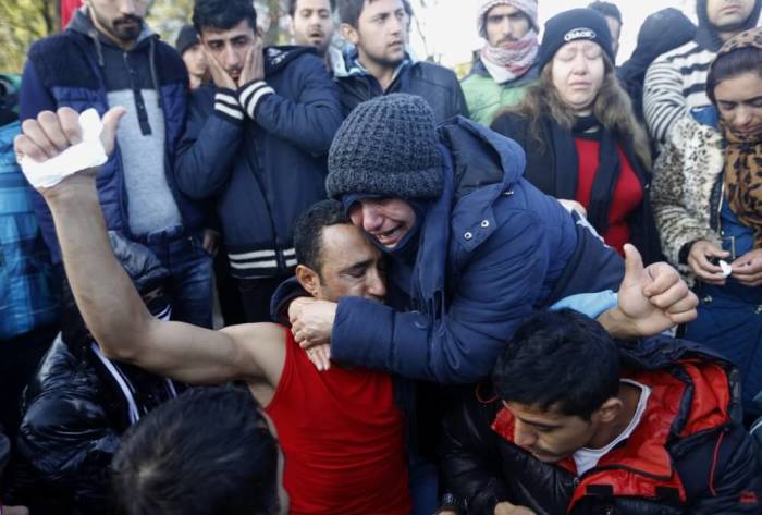 A stranded Iranian woman cries as she embraces a colleague who just had his mouth sewed shut during a protest at the Greek-Macedonian border near the Greek village of Idomeni November 26, 2015. Countries along the Balkan route taken by hundreds of thousands of migrants seeking refuge in western Europe last week began filtering the flow, granting passage only to those fleeing conflict in Syria, Iraq and Afghanistan.