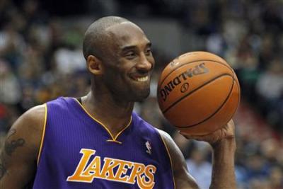 LA Lakers guard Kobe Bryant puts up a smile while handing the ball over to an official during his team's game against the Minnesota Timberwolves in 2012.