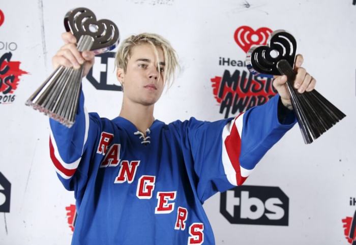 Recording artist Justin Bieber poses with his Dance Song of The Year Award for 'Where Are U Now' and Male Artist of the Year Award backstage at the 2016 iHeartRadio Music Awards in Inglewood, California, April 3, 2016.