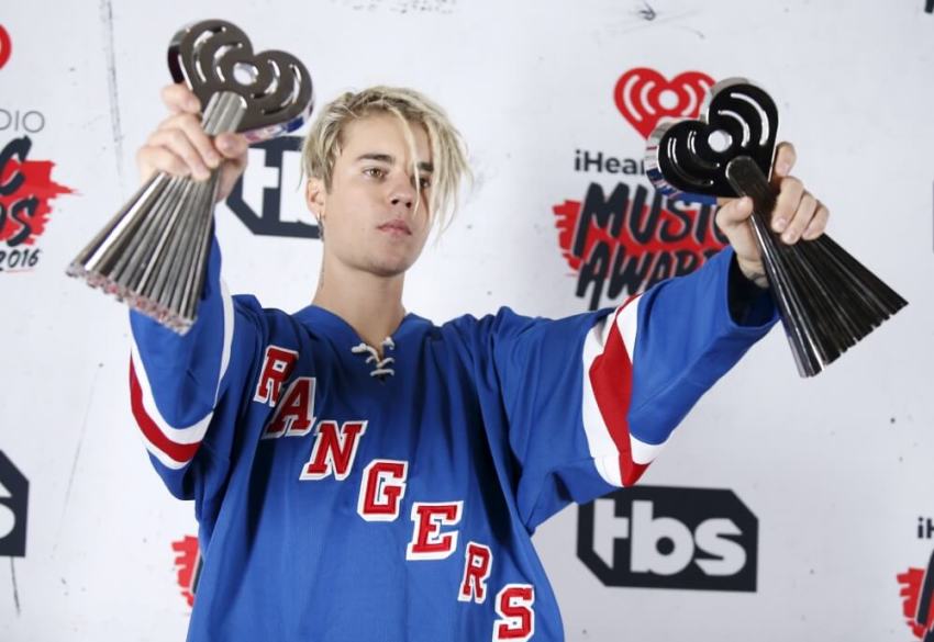 Recording artist Justin Bieber poses with his Dance Song of The Year Award for "Where Are U Now" and Male Artist of the Year Award backstage at the 2016 iHeartRadio Music Awards in Inglewood, California, April 3, 2016.
