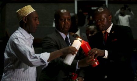 Kenya's National Counter Terrorism Centre Director Martin Kimani (C) is assisted to light a candle during prayers to commemorate the first anniversary of the attack at the Garissa University College, in Kenya's capital Nairobi, April 2, 2016.