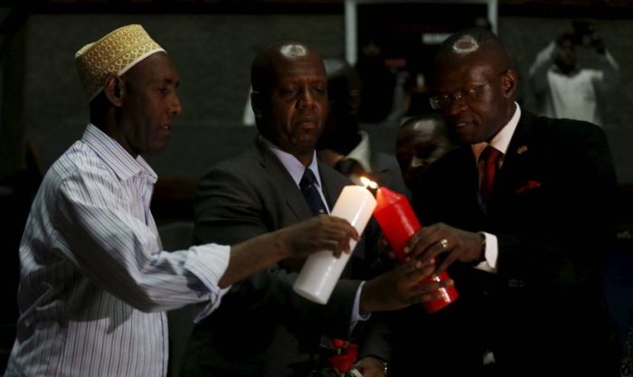 Kenya's National Counter Terrorism Centre Director Martin Kimani (C) is assisted to light a candle during prayers to commemorate the first anniversary of the attack at the Garissa University College, in Kenya's capital Nairobi, April 2, 2016.