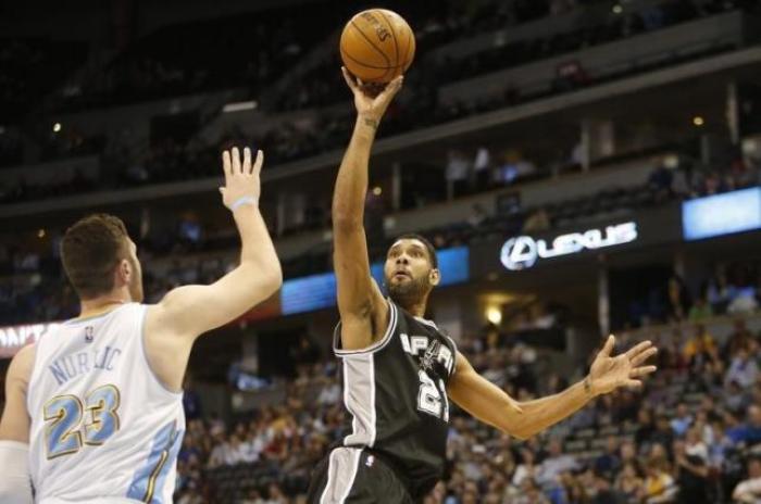 Tim Duncan of the San Antonio Spurs puts a shot against Jusuf Nurkic of the Denver Nuggets.