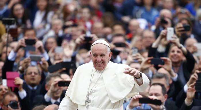 Pope Francis waves as he arrives to lead the weekly audience in Saint Peter's Square at the Vatican, April 13, 2016.