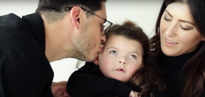 Julia Veach holds Georgia as Chad Veach kisses the head of his daughter, 2016.