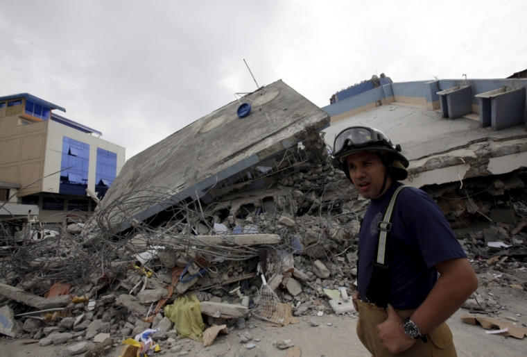 A firefighter walks past a collapsed building after an earthquake struck off the Pacific coast, in Guayaquil, Ecuador, April 17, 2016.