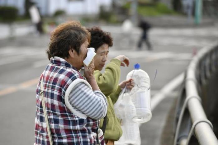 A woman cries as she looks at her collapsed house caused by an earthquake in Mashiki town, Kumamoto prefecture, southern Japan, in this photo taken by Kyodo April 17, 2016.