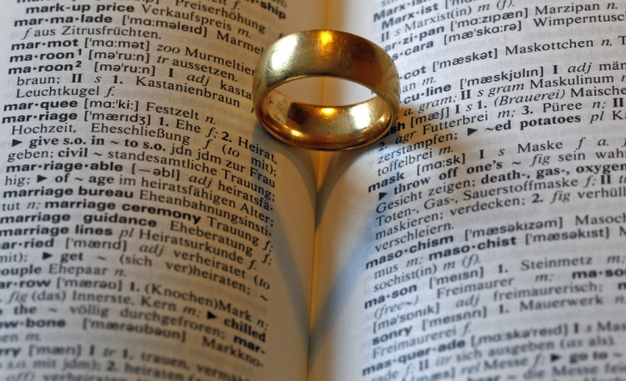 A wedding ring casts a heart-shaped shadow next to the words marriage (hochzeit) in an English-German dictionary in Munich on February 10, 2012.