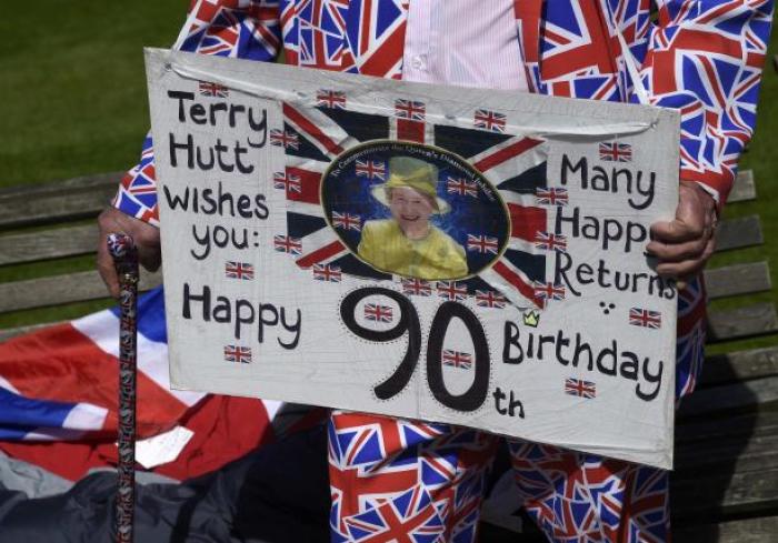 Royal fan Terry Hutt holds a placard as he stands outside of Windsor Castle in Windsor Britain April 20, 2016. Britain's Queen Elizabeth celebrates her 90th birthday in Windsor on April 21.