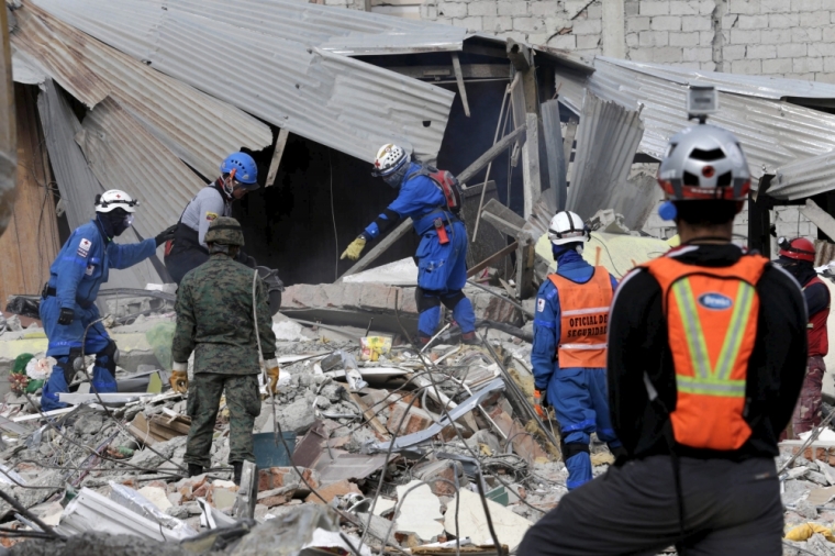 Red Cross members and rescue team search for victims at a collapsed building in Pedernales, after an earthquake struck off Ecuador's Pacific coast, April 20, 2016.