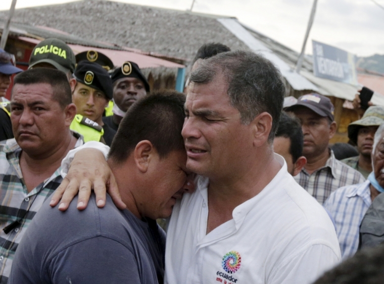 Ecuador's President Rafael Correa (R) embraces a resident after the earthquake, which struck off the Pacific coast, in the town of Canoa, Ecuador, April 18, 2016.
