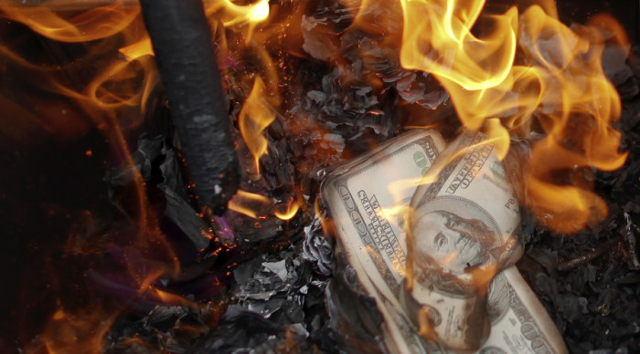 U.S. currency burns in a fire.