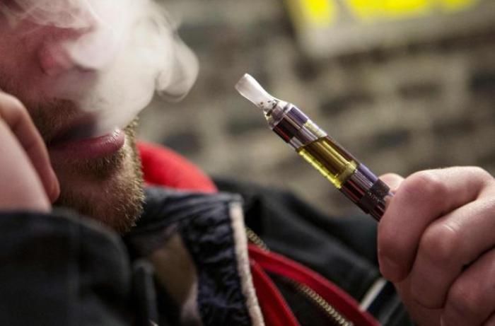 A man puffs an e-cigarette in Henley Vaporium in New York City.