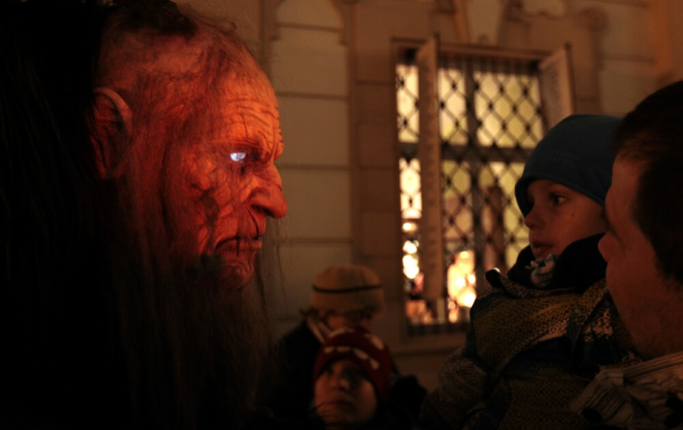 A child looks at a reveler dressed as a devil at the Old Town Square in Prague, Czech Republic on the eve of Saint Nicholas Day on December 5, 2013.