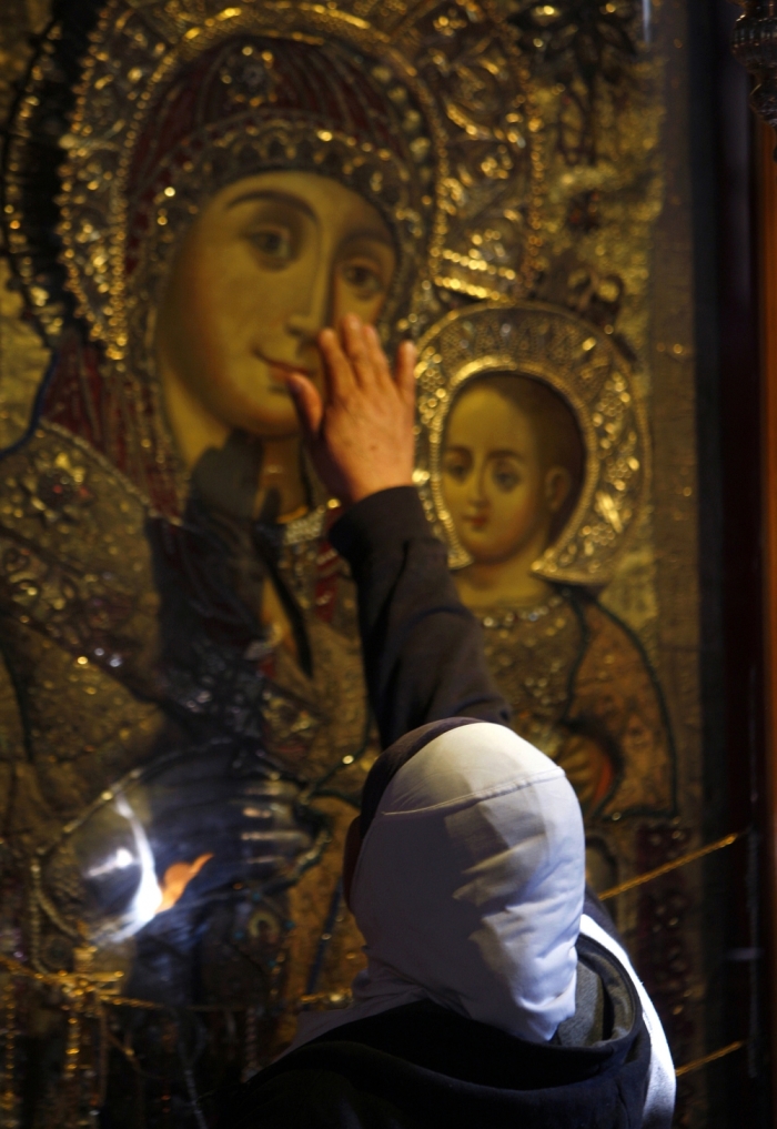 A worshipper touches an icon of the Virgin Mary in the Church of the Nativity in the West Bank town of Bethlehem, November 30, 2008. The church was built over the grotto where Christians believe the Virgin Mary gave birth to Jesus.