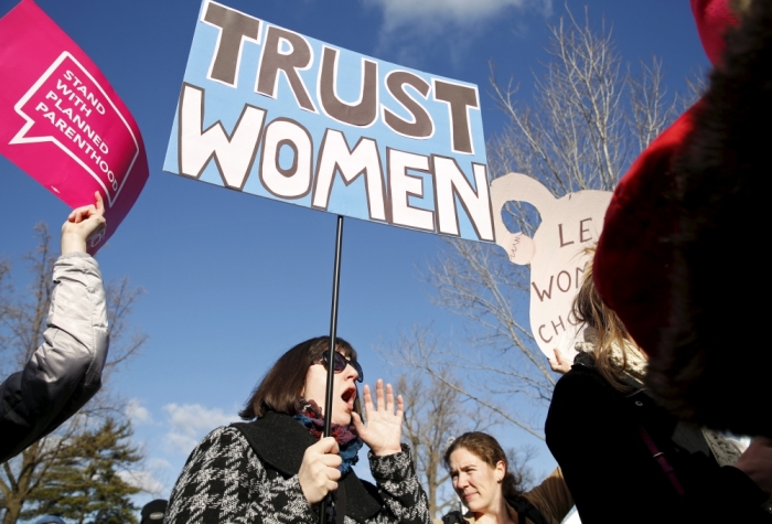 Protesters hold signs in front of the U.S. Supreme Court on the morning the court takes up a major abortion case focusing on whether a Texas law that imposes strict regulations on abortion doctors and clinic buildings interferes with the constitutional right of a woman to end her pregnancy, in Washington March 2, 2016.