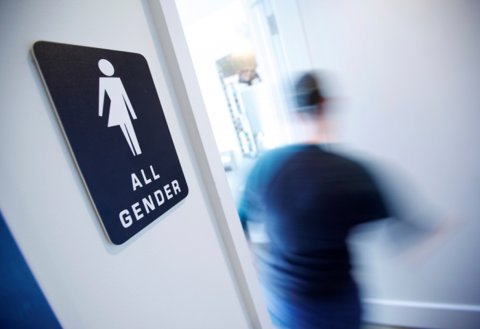 A bathroom sign welcomes both genders at the Cacao Cinnamon coffee shop in Durham, North Carolina May 3, 2016. The shop installed the signs after North Carolina's 'bathroom law' gained national attention, positioning the state at the center of a debate over equality, privacy and religious freedom.