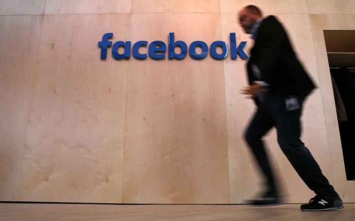 A man walks in front of the Facebook logo at the new Facebook Innovation Hub during a preview media tour in Berlin, Germany, February 24, 2016.