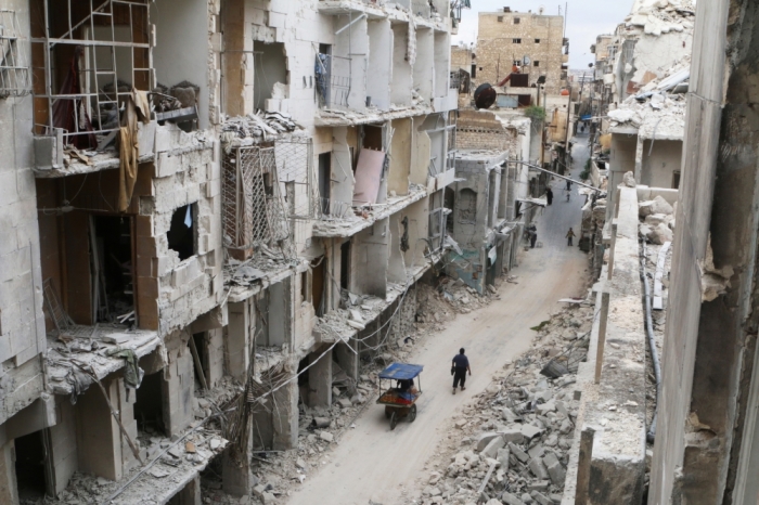 Residents walk near damaged buildings in the rebel held area of Old Aleppo, Syria May 5, 2016.