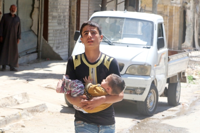 A civilian evacuates a baby from a site hit by airstrikes in the rebel held area of Aleppo's al-Fardous district, Syria, April 29, 2016.