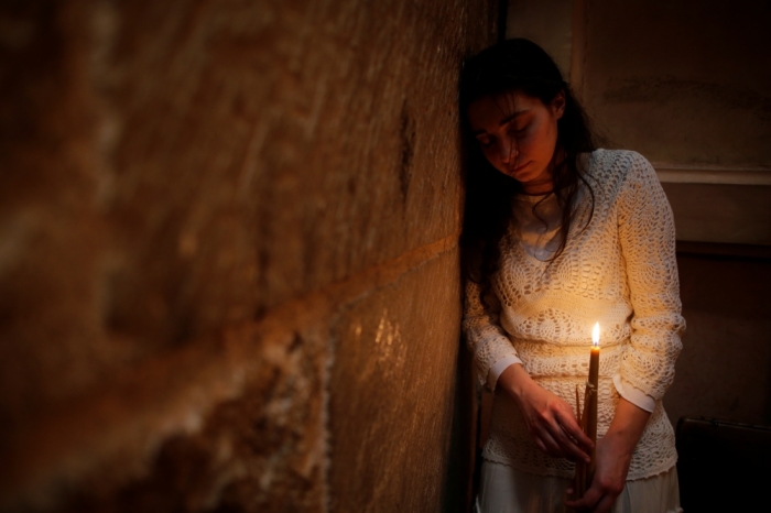 A Christian worshipper holds a candle as she takes part in the Christian Orthodox Holy Fire ceremony at the Church of the Holy Sepulchre in Jerusalem's Old City, April 30, 2016.