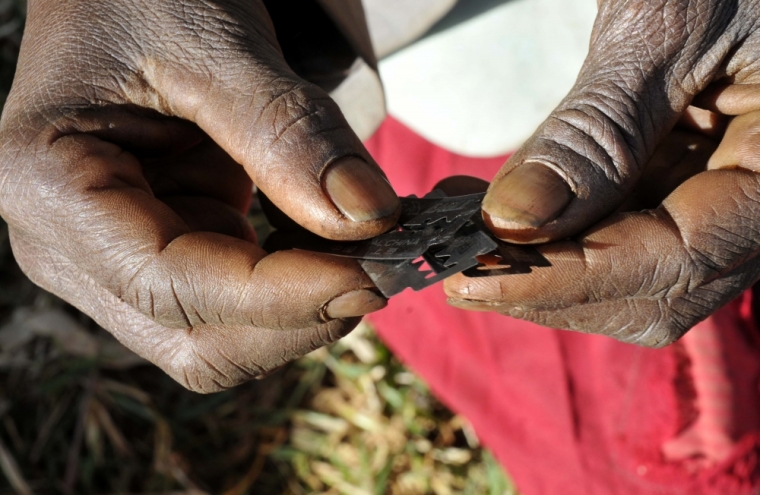 Prisca Korein, a 62-year-old traditional surgeon, holds razor blades before carrying out female genital mutilation on teenage girls from the Sebei tribe in Bukwa district, about 357 kms (214 miles) northeast of Kampala, December 15, 2008. The ceremony was to initiate the teenagers into womanhood, according to Sebei traditional rites.