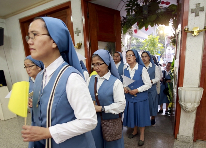 Catholic nuns enter through a door of the Our Lady of Sorrows Parish church to symbolically start the observance of the Holy Year of Mercy, or Jubilee, in Pasay city, metro Manila, Philippines, December 13, 2015.