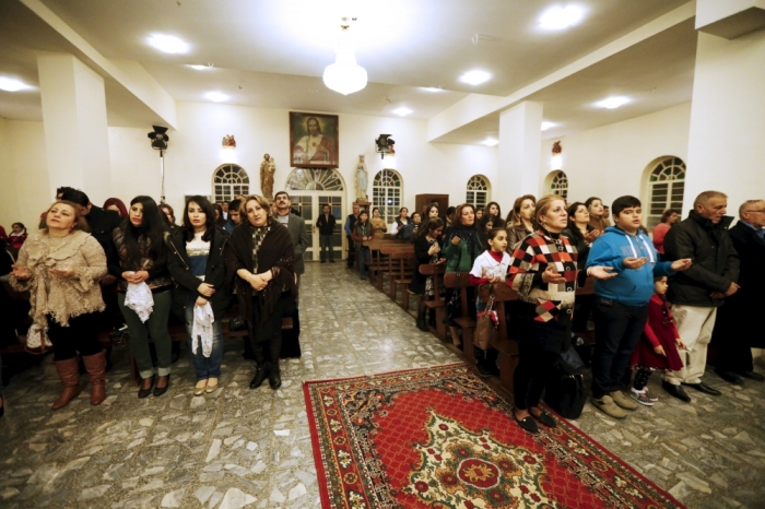 Iraqi Christians pray during a mass on Christmas eve at Sacred Heart Catholic Church in Baghdad, Iraq, December 24, 2015.