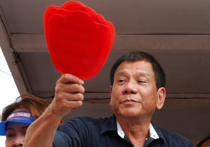 Presidential candidate Rodrigo 'Digong' Duterte holds election souvenir fans, May 4, 2016