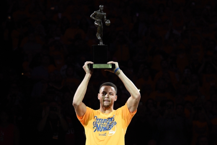 Golden State Warriors guard Stephen Curry (30) hoists the MVP trophy before game five of the second round of the NBA Playoffs against the Portland Trail Blazers at Oracle Arena, Oakland, California, May 11, 2016.