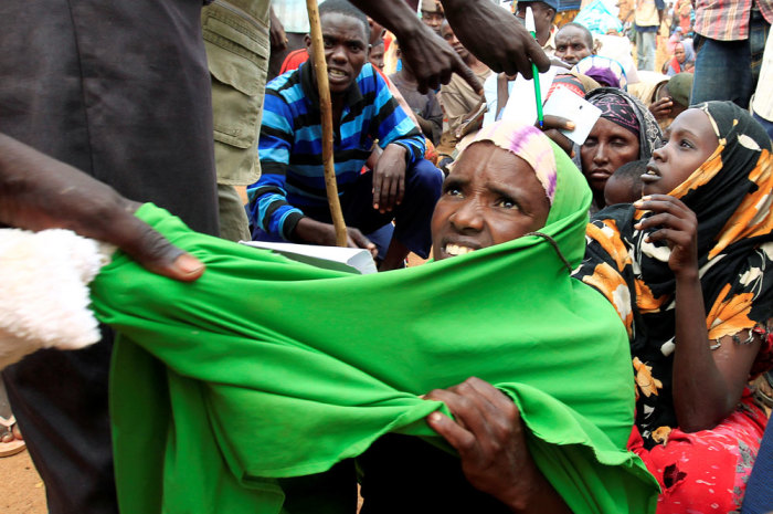 A newly arrived Somali refugee is forced out of the queue outside a reception centre in the Ifo 2 refugee camp in Dadaab, near the Kenya-Somalia border, in Garissa County, Kenya July 28, 2011.