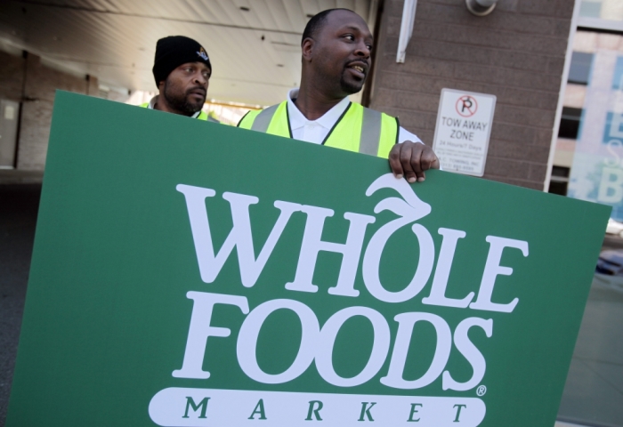 Troy Moss holds a sign as he directs traffic towards parking for the site of a ground breaking ceremony of the new 20,000-square-foot Whole Foods Market scheduled to open next year in mid-town Detroit, Michigan, May 14, 2012.