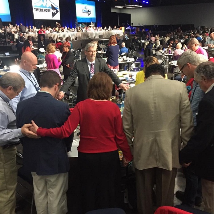 Delegates pray before a plenary session at the United Methodist Church's 2016 General Conference in Portland, Oregon.