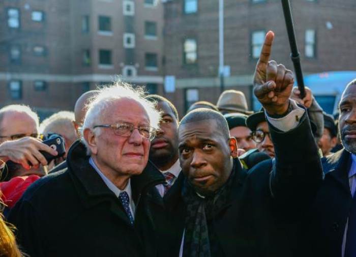 U.S. Democratic presidential candidate Sen. Bernie Sanders (I-VT) stands with Pastor Jamal Bryant (R) near the site of last spring's riots in Baltimore, Maryland, December 8, 2015.