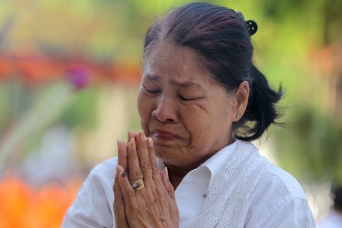A woman prays at the Choeung Ek memorial during the annual 'Day of Anger,' where people gather to remember those who perished during the communist Khmer Rouge regime, in Phnom Penh, Cambodia, May 20, 2016.