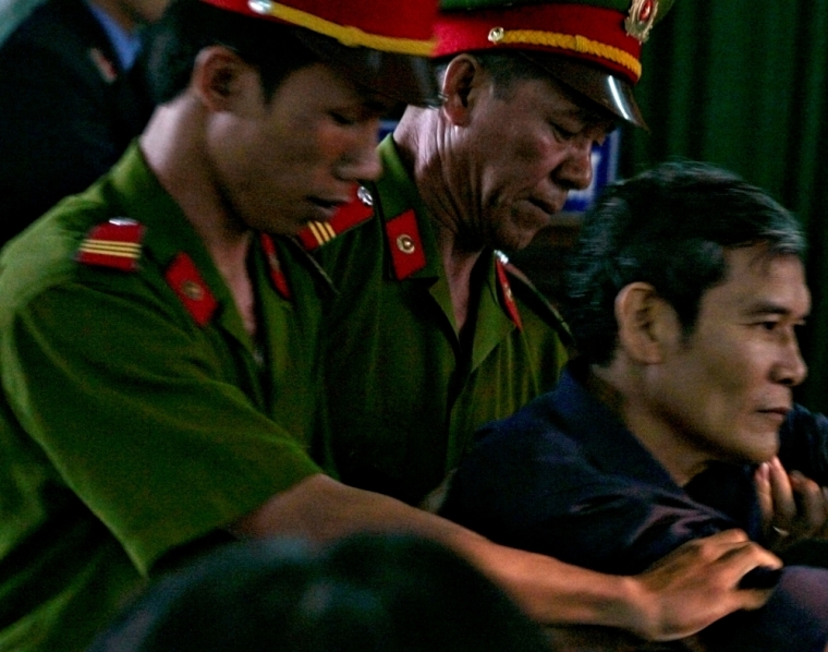 Vietnamese dissident priest Father Thadeus Nguyen Van Ly (R) is escorted by police as he faces a court in Vietnam's central Hue City March 30, 2007.