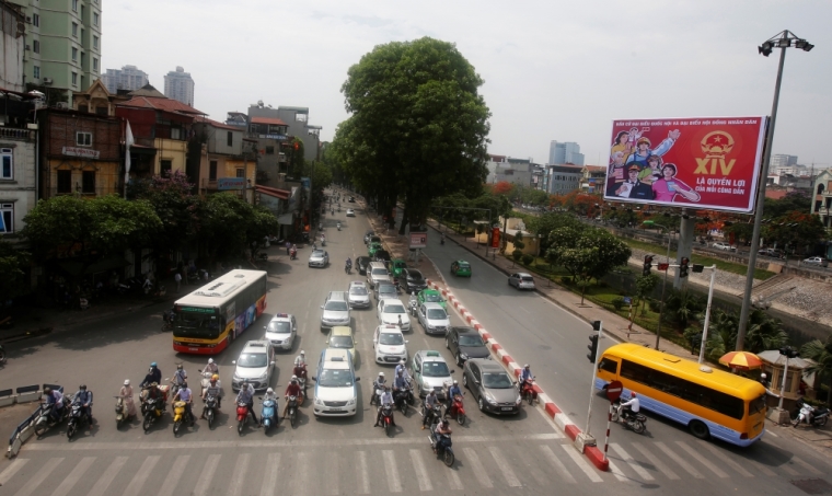Commuters stop near a poster promoting the 14th National Assembly election on a street in Hanoi, Vietnam May 20, 2016. Communist Vietnam holds its five-yearly day of democracy on Sunday with an election for its parliament, and the only national poll in a country tightly controlled by one party for 41 years. The secretive Communist Party has been on a publicity blitz to showcase its democratic credentials, with the rural roads and the streets of its bustling cities festooned with billboards of a hammer and sickle and the workers, farmers and soldiers synonymous with the stateÕs socialist foundations. The poster reads: 'Voting for members of the National Assembly and People's councils is a citizen's right.'