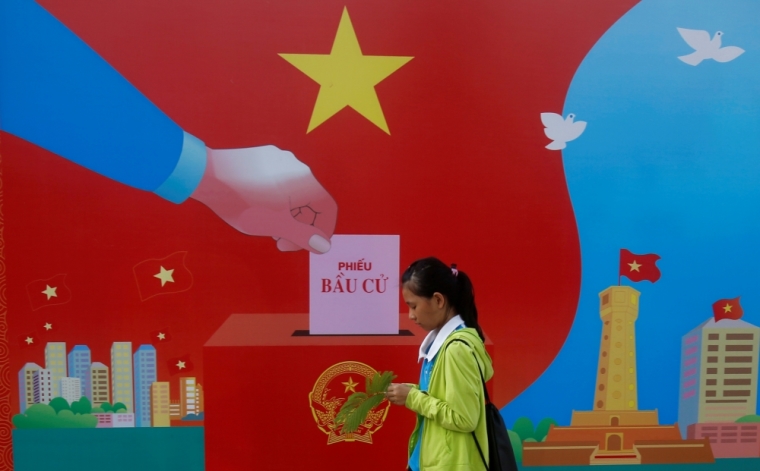 A girl walks past a poster promoting the 14th National Assembly election on a street in Hanoi, Vietnam May 20, 2016. Communist Vietnam holds its five-yearly day of democracy on Sunday with an election for its parliament, and the only national poll in a country tightly controlled by one party for 41 years. The secretive Communist Party has been on a publicity blitz to showcase its democratic credentials, with the rural roads and the streets of its bustling cities festooned with billboards of a hammer and sickle and the workers, farmers and soldiers synonymous with the state's socialist foundations. The words on the poster read: 'Voting ballot.'