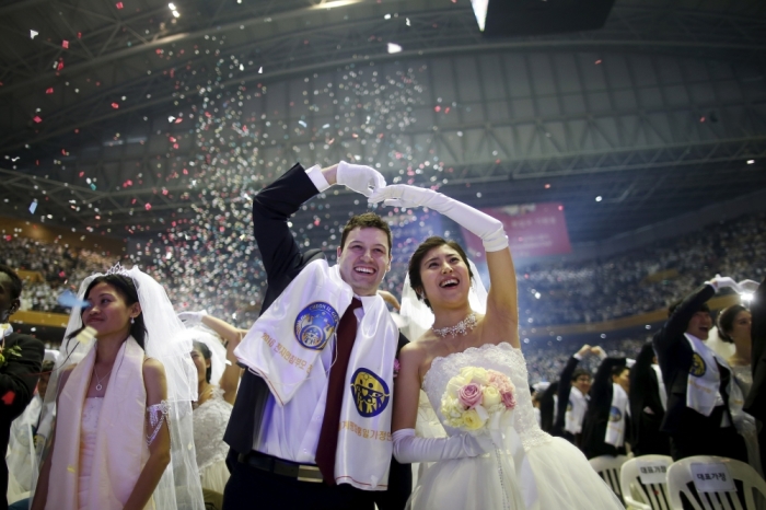 A newlywed couple celebrates during a mass wedding ceremony of the Unification Church at Cheongshim Peace World Centre in Gapyeong, South Korea, February 20, 2016.